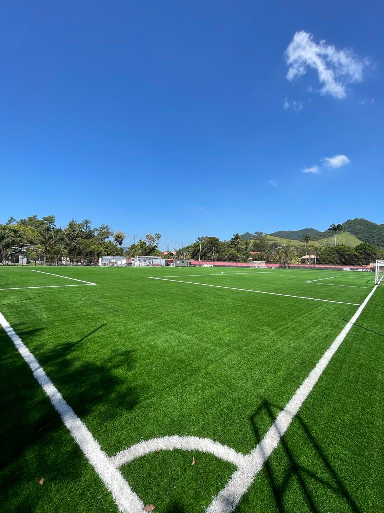 Cancha de fútbol con césped sintético bajo cielo azul